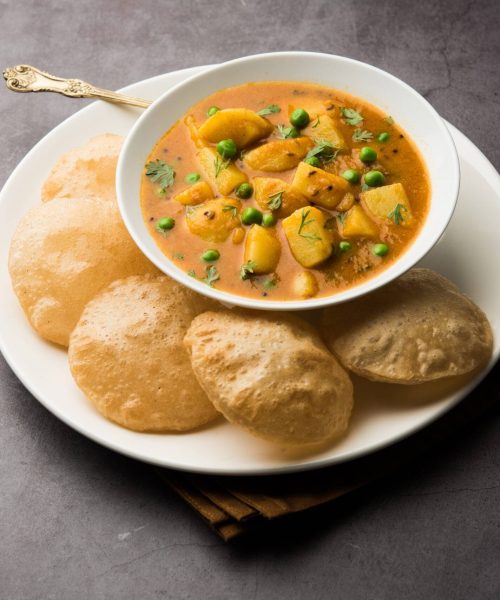 Aloo Puri or Potato curry with fried Poori, popular Indian breakfast or lunch or dinner menu.